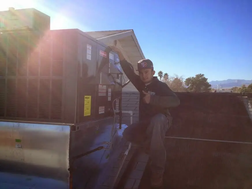 HVAC technician performing AC Tune-Up on a rooftop unit in Elyria